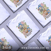 Футболка Cloudzy Labubu білого кольору, зображена з фронтального ракурсу на манекені, фон світло-сірий, принт містить персонажів з великими головами та веселими виразами облич, оточених купюрами.