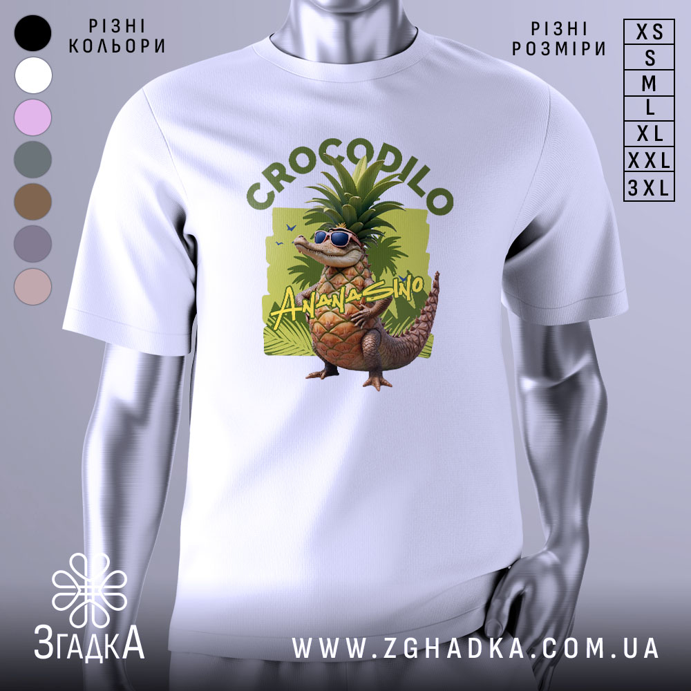 Футболка Crocodillo Ananasinno білого кольору, зображена з фронтального ракурсу на манекені, фон світло-сірий, принт з веселим ящіркою в окулярах та ананасом на голові, оточений зеленими елементами.