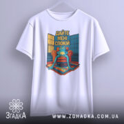 Футболка дайте спокій, біла, підвішена на вішалці, фон сірий, принт з лягушкою на кріслі, текст 'Дайте мені спокій' на фоні вікон.