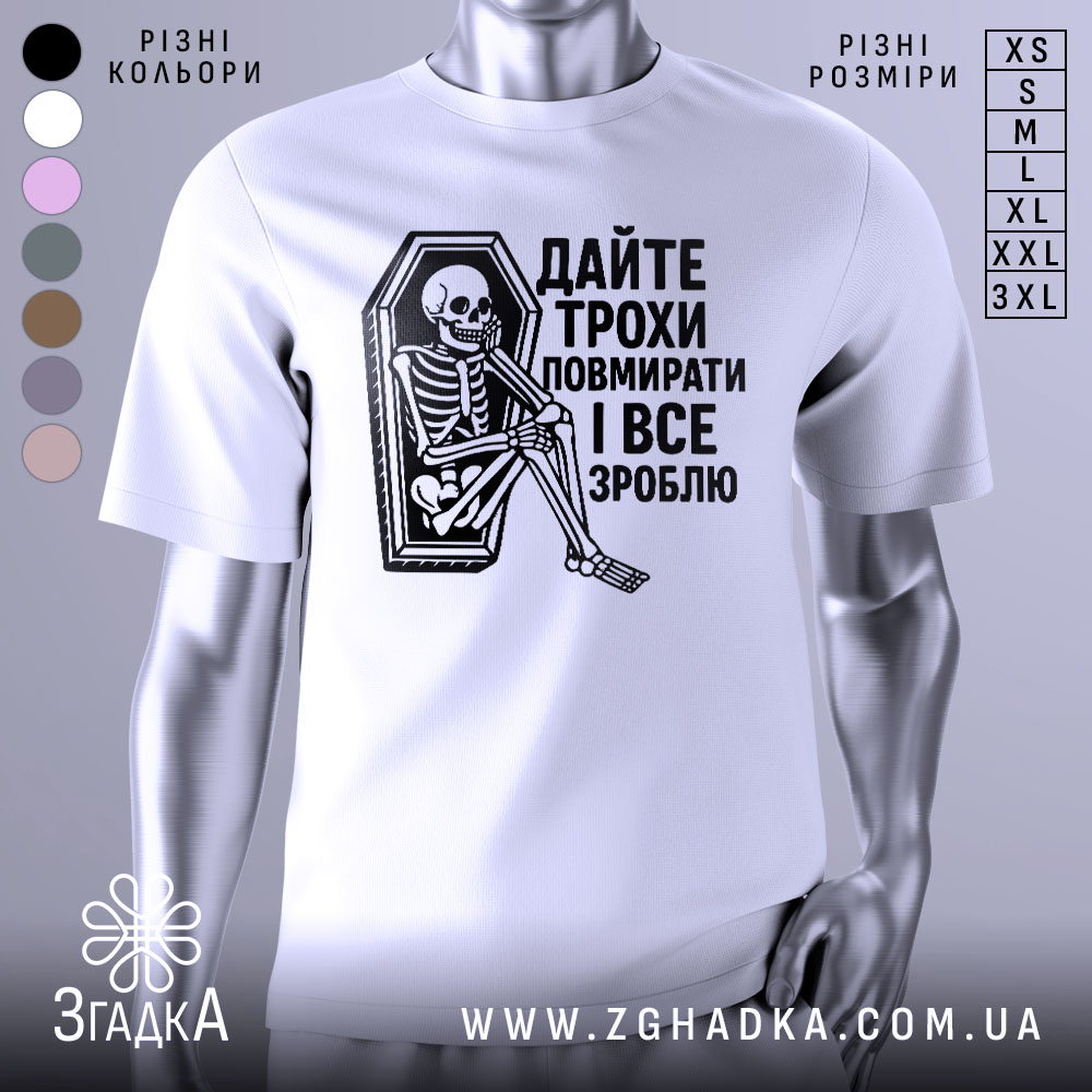Футболка дайте трохи повмирати, біла, зображена з фронтального ракурсу, на манекені, фон світло-сірий, принт чорного кольору з малюнком скелета, що сидить у труні, текст українською мовою.