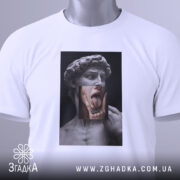 Футболка Давид арт, біла, складена на поверхні, фон світло-сірий, принт зображає статую Давида з язиком, що висунений, та рукою, що торкається обличчя, з етикеткою на шнурку.