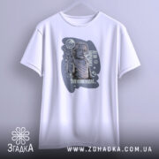 Футболка де ви навчалися, біла, зображена на вішалці, фон світло-сірий, принт з зображенням людини, що піднімає руку, з текстом і графічними елементами.