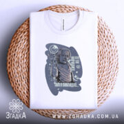 Футболка де ви навчалися, біла, зображена зверху на плетеній основі, фон світло-сірий, принт з зображенням людини, що піднімає руку, з текстом і графічними елементами.