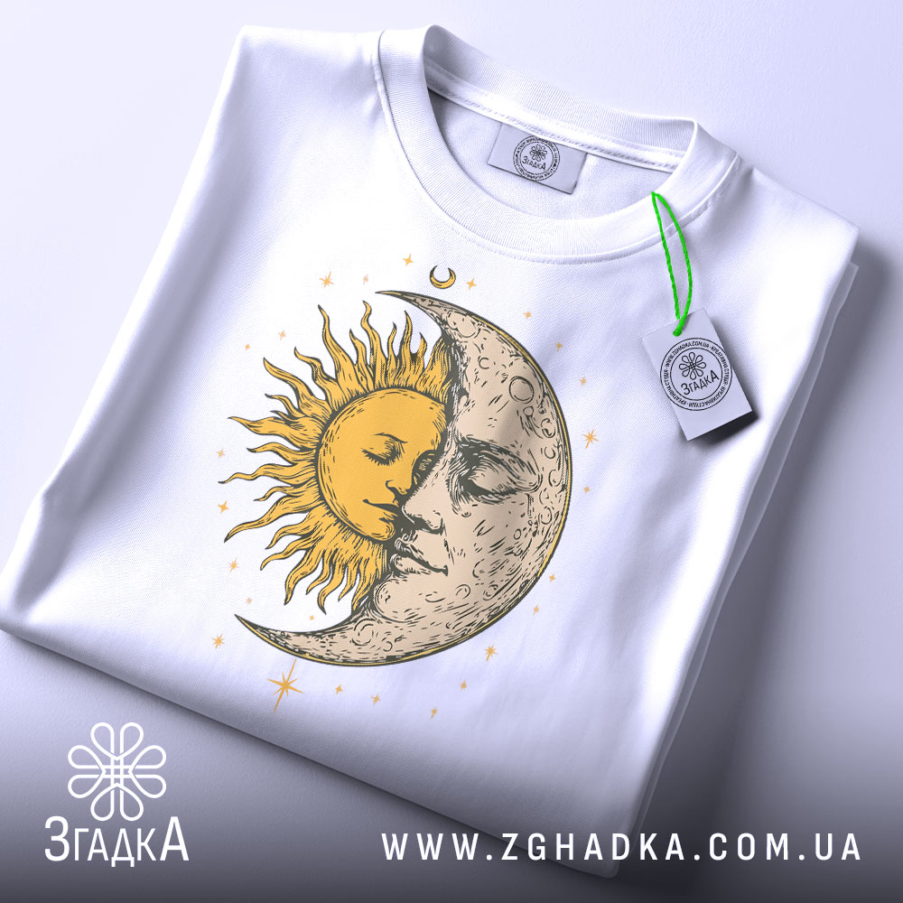 Футболка день ніч, біла, зображена з верхнього ракурсу, фон світло-сірий, принт з сонцем і місяцем, що зображують обличчя, жовті та сірі деталі, з етикеткою на зеленому шнурку.