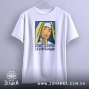 Футболка дякую за п`ятницю, біла, підвішена на вішалці, фон світло-сірий, принт зображає жінку в хустці, яка тримає палець на губах, кольори принта жовтий, синій та оранжевий.