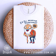 Футболка дід хоче Рамштайн, біла, складена на плетеному кошику, фон білий, принт з дідусем у червоній сорочці в клітинку, який тримає палицю, текст 'Ей DJ, включай Рамштайн!!!'.