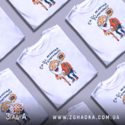 Футболка дід хоче Рамштайн, біла, зображена на манекені з правого боку, фон світло-сірий, принт з веселим дідусем у червоній сорочці в клітинку, який тримає палицю та говорить 'Ей DJ, включай Рамштайн!!!'.