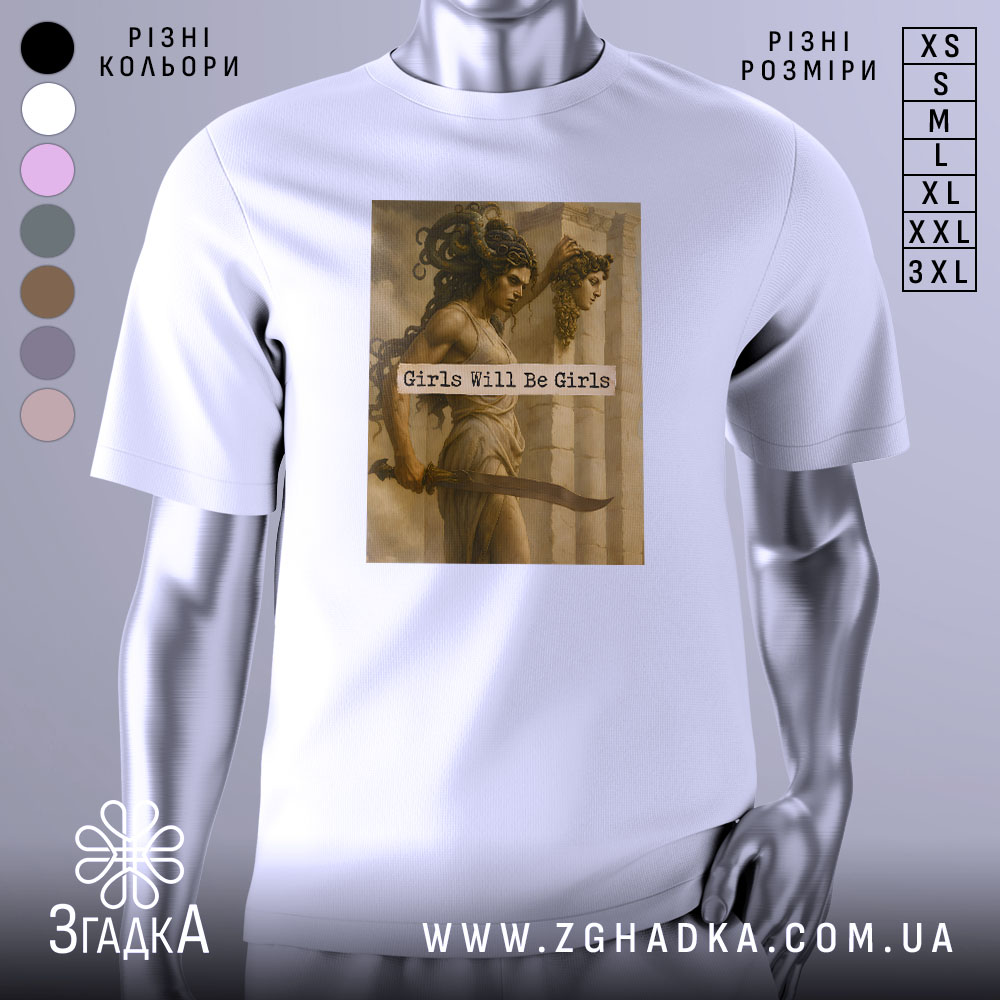 Футболка дівчата можуть бути білого кольору, з прямим кроєм, на манекені з правого боку. На футболці розташований принт з зображенням двох жінок, одна з яких тримає меч, а текст "Girls Will Be Girls" розміщений на фоні.