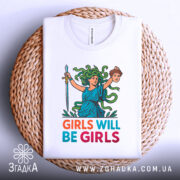 Футболка дівчата такі дівчата, біла, зображена зверху, фон світло-сірий, принт з дівчиною з зеленим волоссям, що тримає меч і голову, текст 'GIRLS WILL BE GIRLS' яскравих кольорів, футболка лежить на плетеній основі.