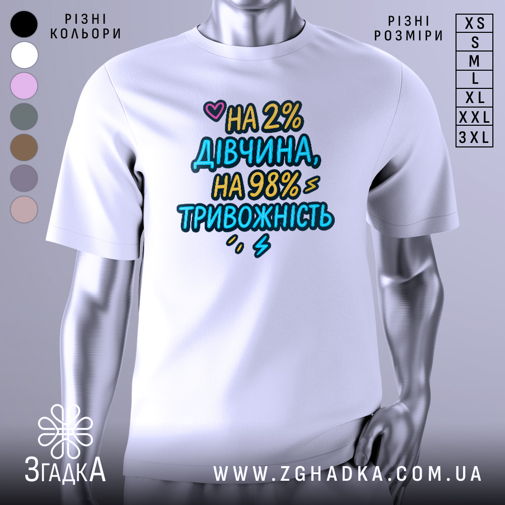 Футболка дівчина тривожність подарунок. Біла футболка на манекені, з принтом на грудях, текст кольоровий: 'НА 2% ДІВЧИНА, НА 98% ТРИВОЖНІСТЬ'. Фон світло-сірий, акцент на принті.