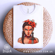 Футболка Дівчина Войовниця, біла, складена на кошику, фон світло-сірий, принт з зображенням дівчини з червоними квітами на голові та мечем, етикетка видна на комірці.