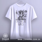 Футболка дівоча помста, біла, підвішена на вішалці, фон світло-сірий, принт з дівчиною з мечем та написом 'GIRLS WILL BE GIRLS'.