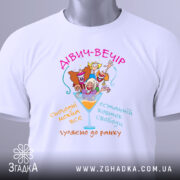 Футболка дівич-вечір білого кольору, зображена на столі, з принтом, що містить кольорові малюнки жінок у святкових капелюшках, текстом на українській мові, з етикеткою на комірці, фон світло-сірий.