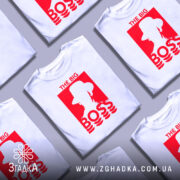 Футболка для босса, білого кольору, зображена з близького ракурсу на манекені, фон світло-сірий, принт червоного кольору з написом 'THE BIG BOSS' та силуетом людини в капелюсі.