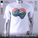 Футболка для мандрівників. Біла футболка з коротким рукавом, зображена з фронтального ракурсу. На грудях великий принт у формі серця з горами, лісом та логотипом 'GO'. Фон нейтральний, що підкреслює яскравість принта.