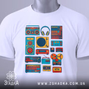 Футболка для меломана, білого кольору, зображена на столі, фон світло-сірий, принт з музичними елементами в яскравих кольорах, на футболці також видно етикетку з логотипом.