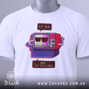 Футболка для олдів, білого кольору, зображена зверху, фон світло-сірий, принт з телевізором у ретро стилі, на футболці є етикетка з логотипом.