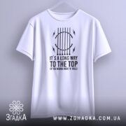 Футболка для рокера, біла, підвішена на вішалці, фон світлий, принт чорного кольору з текстом "IT'S A LONG WAY TO THE TOP (IF YOU WANNA ROCK 'N' ROLL)" та графічними елементами.