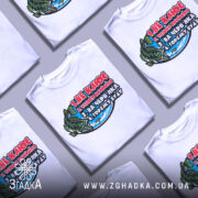 Футболка для риболовлі, білого кольору, зображена з фронтального ракурсу на манекені, фон нейтральний, принт з рибою та текстом яскравих кольорів.