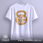 Футболка для спортсменів, біла, підвішена на вішалці, фон світло-сірий, принт з написом 'NO PAIN NO GAIN' у золотистому кольорі, з зображенням гирі.