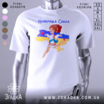 Футболка для свахи білого кольору, зображена з фронтального ракурсу на манекені, фон нейтральний, принт з веселою дівчиною в українському вбранні на фоні карти України з жовтою та синьою смугами.