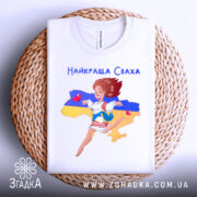 Футболка для свахи білого кольору, складена на плетеній основі, фон світлий, принт з дівчиною в українському вбранні на фоні карти України, з жовтою та синьою смугами.