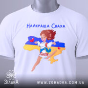 Футболка для свахи білого кольору, складена на столі, фон світлий, принт з дівчиною в українському вбранні, зображена на фоні карти України, з прикріпленою етикеткою.