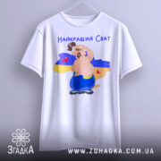 Футболка для свата, біла, підвішена на вішалці, фон нейтральний, принт з веселим персонажем на фоні карти України, текст 'Найкращий Сват' зверху, деталі принта чітко видимі.