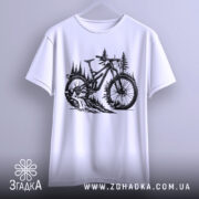 Футболка для велосипедиста, білого кольору, підвішена на вішалці, фон світлий, принт з чорним малюнком велосипеда на фоні лісу з деревами.