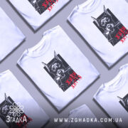 Футболка доберман живи життя, біла футболка на манекені, зображення добермана з пістолетом у пащі на чорному фоні, текст 'ЖИВИ ЖИТТЯ' червоним кольором, фон світло-сірий.