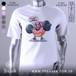 Футболка донат спорт мотивація, біла футболка на манекені, з принтом у вигляді веселого пончика, що піднімає штангу, текст 'DO NUT STOP WORKING' над принтом, фон світло-сірий.