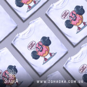 Футболка донат спорт мотивація, біла футболка на манекені, з принтом у вигляді веселого пончика, що піднімає штангу, текст 'DO NUT STOP WORKING' над принтом, фон світло-сірий.