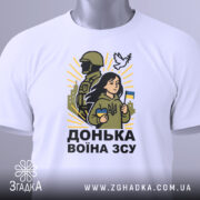 Футболка донька воїна ЗСУ, білого кольору, зображена зверху, фон світло-сірий, принт з дівчиною, солдатом та голубом, на футболці є етикетка з зеленим шнурком.
