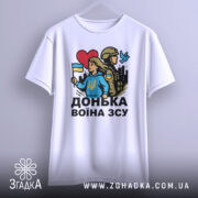 Футболка донька воїна ЗСУ, біла, зображена з фронтального ракурсу, фон світло-сірий, принт з дівчиною у блакитному худі, яка тримає прапор України, поряд солдат у формі, червоне сердечко та голуб.