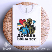 Футболка донька воїна ЗСУ, біла, зображена зверху на плетеній основі, фон світло-сірий, принт з дівчиною у блакитному худі, яка тримає прапор України, поряд солдат у формі, червоне сердечко та голуб.