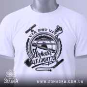 Футболка дорога це життя, складена біла футболка з чорним принтом, зображена на білому фоні, принт містить текст "Дорога це життя" та зображення інструментів, на футболці є етикетка з зеленим шнурком.