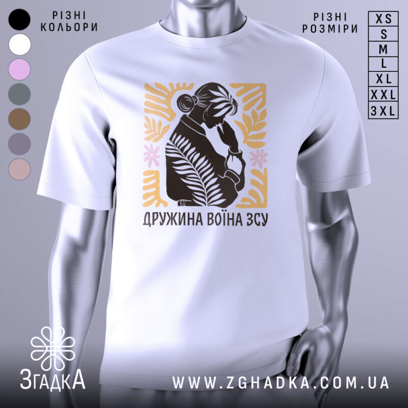 Футболка дружина воїна ЗСУ, біла, зображена на манекені з правого боку, фон світло-сірий, принт з силуетом жінки, що тримає руку на обличчі, оточений рослинними елементами в жовтому та рожевому кольорах.