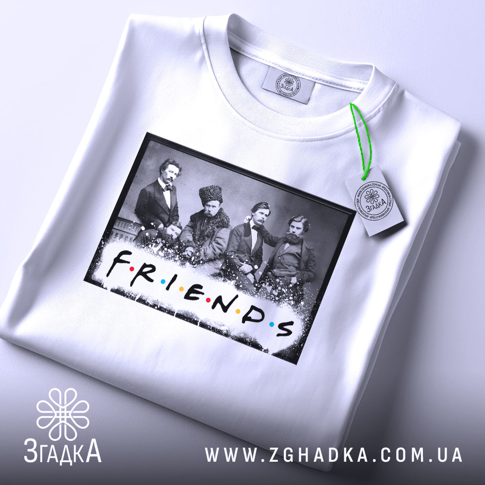 Футболка друзі письменники, біла, складена на поверхні, фон світло-сірий, принт з чорно-білою фотографією людей та написом 'FRIENDS' кольоровими літерами, з зеленим ярликом.