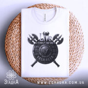 Футболка дух Вальгалли, біла, складена на плетеній основі, фон світлий, принт з написом 'Live WITHOUT REGRET' та щитом, видно деталі дизайну.