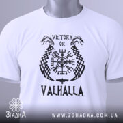 Футболка дух вікінга, біла, зображена зверху, на столі, фон світло-сірий, принт чорного кольору з написом 'VICTORY OR VALHALLA' та зеленим ярликом.