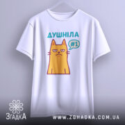 Футболка душніла жарт, біла, підвішена на вішалці, фон світло-сірий, принт з жовтим котом з незадоволеним виразом обличчя та написом "Душніла #1" у кольорах бірюзовий та фіолетовий.