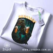 Футболка дикий пивозавр, біла, складена на поверхні, фон світлий, принт з пивозавром, що тримає два келихи пива, з етикеткою на рукаві.