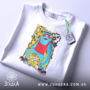 Футболка диско фрік білого кольору, складена на поверхні, фон світлий, принт яскравий, зображає персонажа в червоному топі, з зеленими окулярами і жовтими елементами.