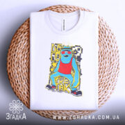 Футболка диско фрік білого кольору, складена на плетеній кошику, фон світлий, принт яскравий, зображає персонажа в червоному топі, з зеленими окулярами і жовтими елементами.