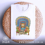 Футболка дивні істоти, складена на плетеній кошику, фон світло-сірий, принт кольоровий, зображує різноманітних істот, центральна фігура з рудим волоссям, на футболці видно етикетку.