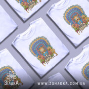 Футболка дивні істоти, біла, зображена на манекені, фон світло-сірий, принт з яскравими кольорами, на якому зображені різноманітні фантастичні істоти та обличчя, центральна фігура з рудим волоссям і сльозами.