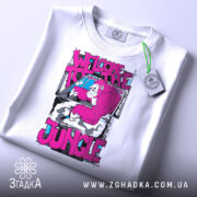 Футболка джунглі стиль, біла, зображена зверху, на фоні світло-сірого градієнту, принт з малюнком горили в рожевих тонах та текстом 'WELCOME TO THE JUNGLE', з етикеткою зеленого кольору.