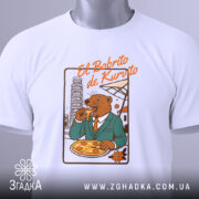 Футболка El Bobrito білого кольору, складена на поверхні, з принтом ведмедя в костюмі, який їсть піцу, з етикеткою на зеленому шнурку.