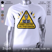 Футболка електрик був провідником. Біла футболка на манекені, з принтом у вигляді жовтого трикутника з чорним контуром, всередині якого зображений скелет з усмішкою. На фоні видно світло-сірий колір. Принт доповнений блискавками.