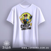Футболка електрик подарунок, біла, підвішена на вішалці, фон градієнтний сірий, принт з супергероєм, що тримає лампочку та електричний шнур, текст 'СУПЕР ЕЛЕКТРИК' внизу.